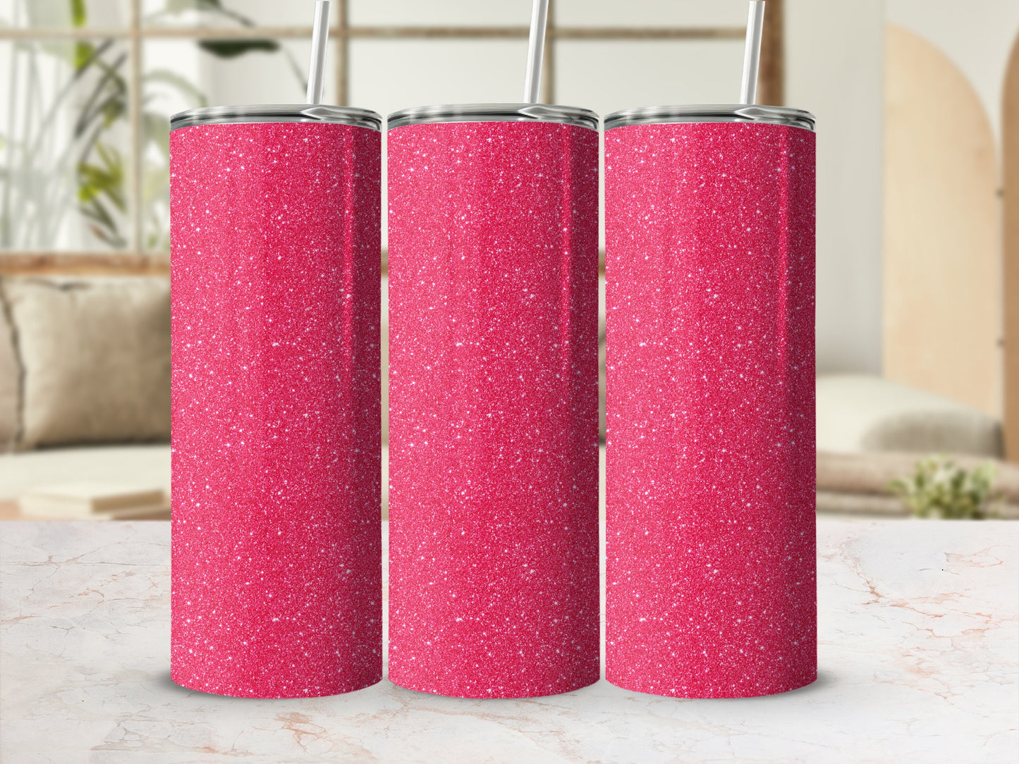Three pink glitter tumblers with silver lids and white straws on a marble surface.