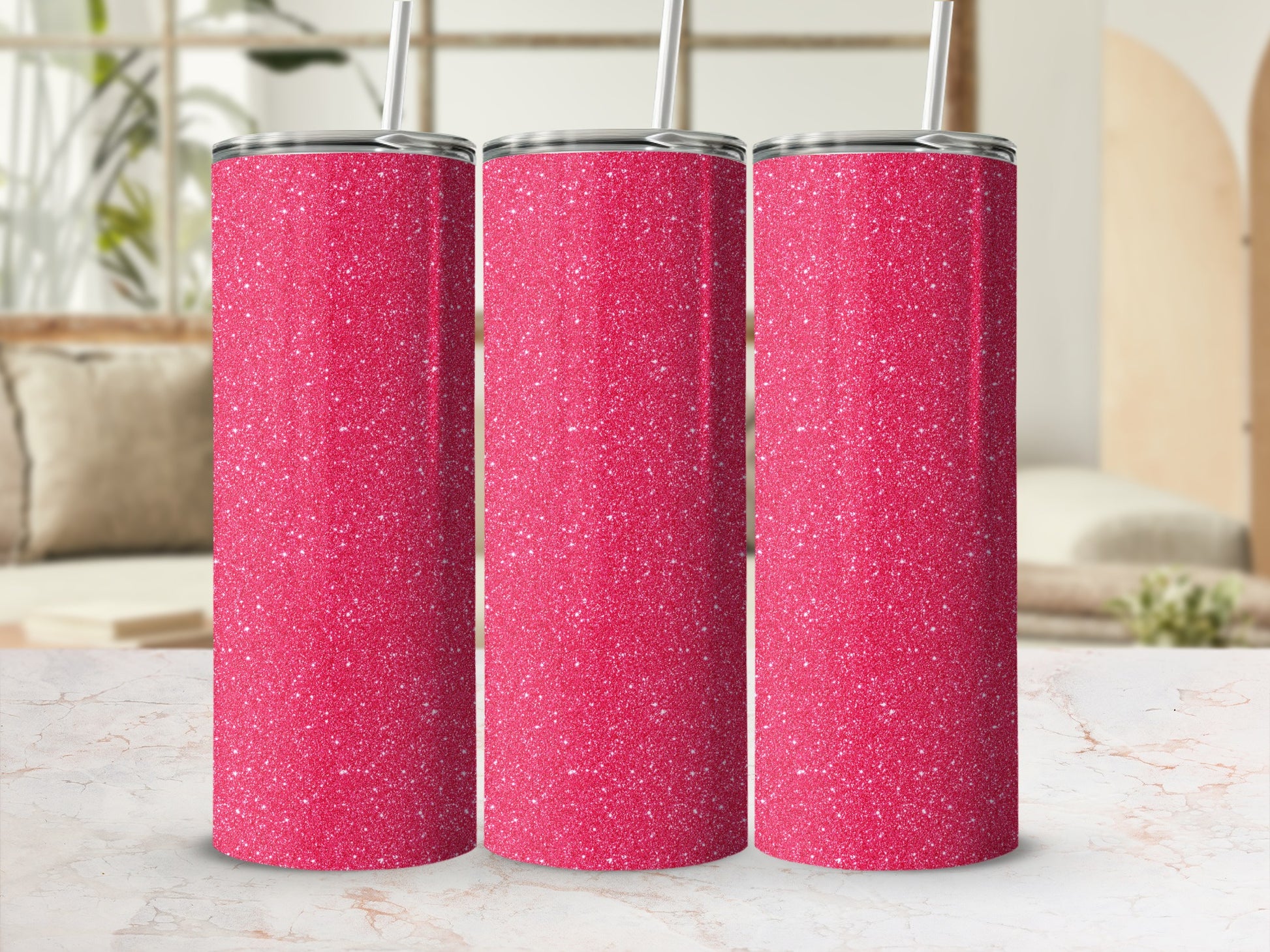 Three pink glitter tumblers with silver lids and white straws on a marble surface.