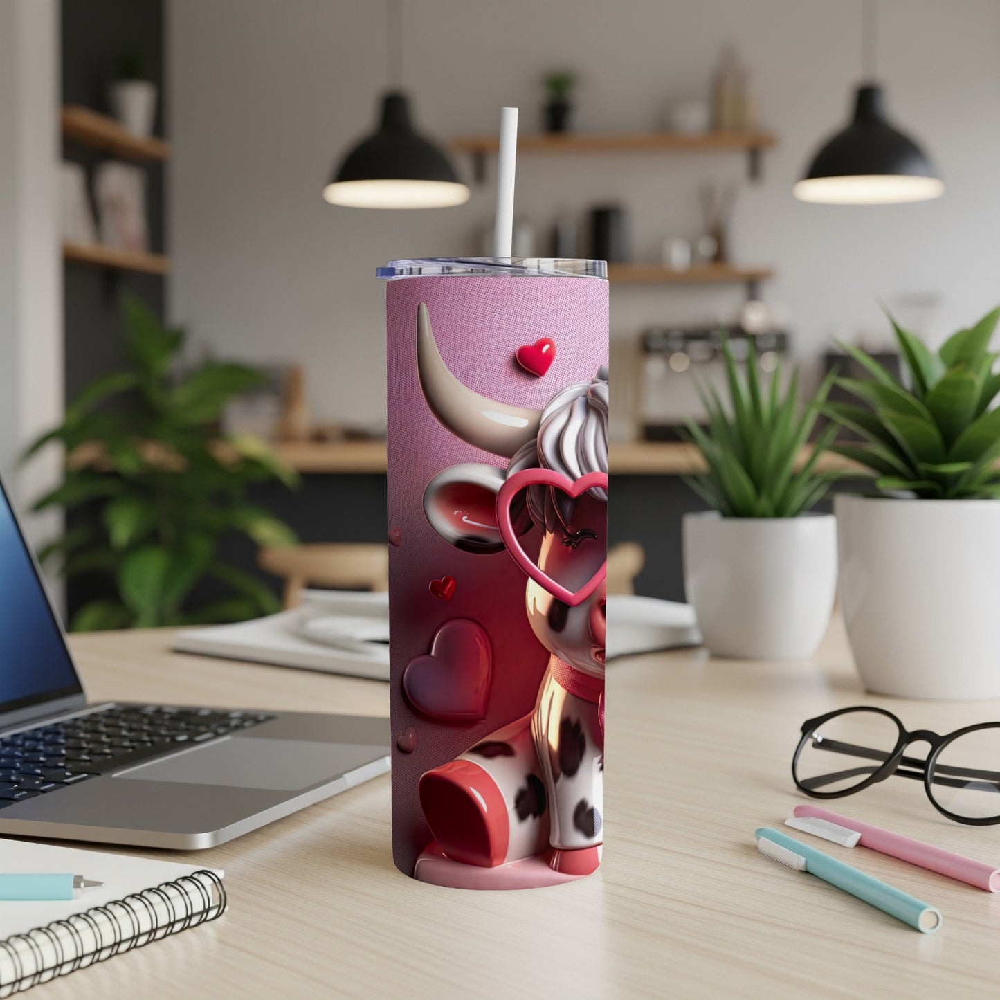 Pink tumbler with a cartoon cow wearing heart sunglasses, sitting on a desk.
