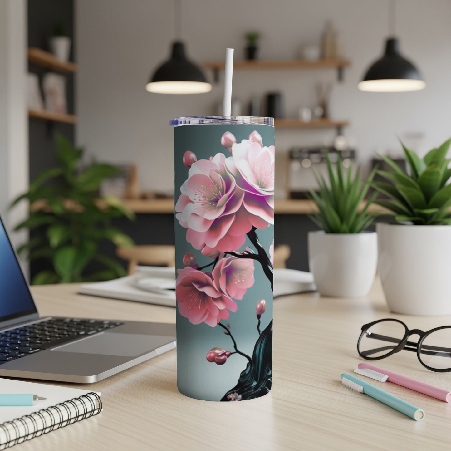 Cherry blossom tumbler with straw on a wooden desk.