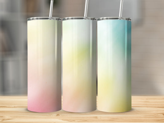 Three tumblers with ombre gradient backgrounds on a wooden surface.