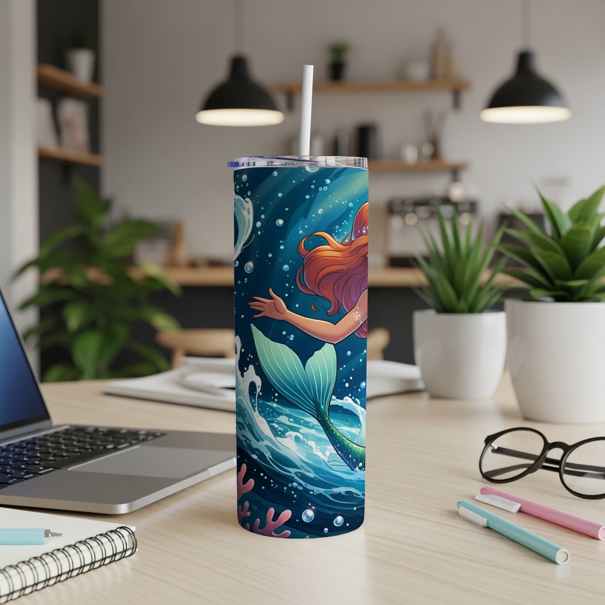 Mermaid on a blue, bubbly tumbler with coral and bubbles.