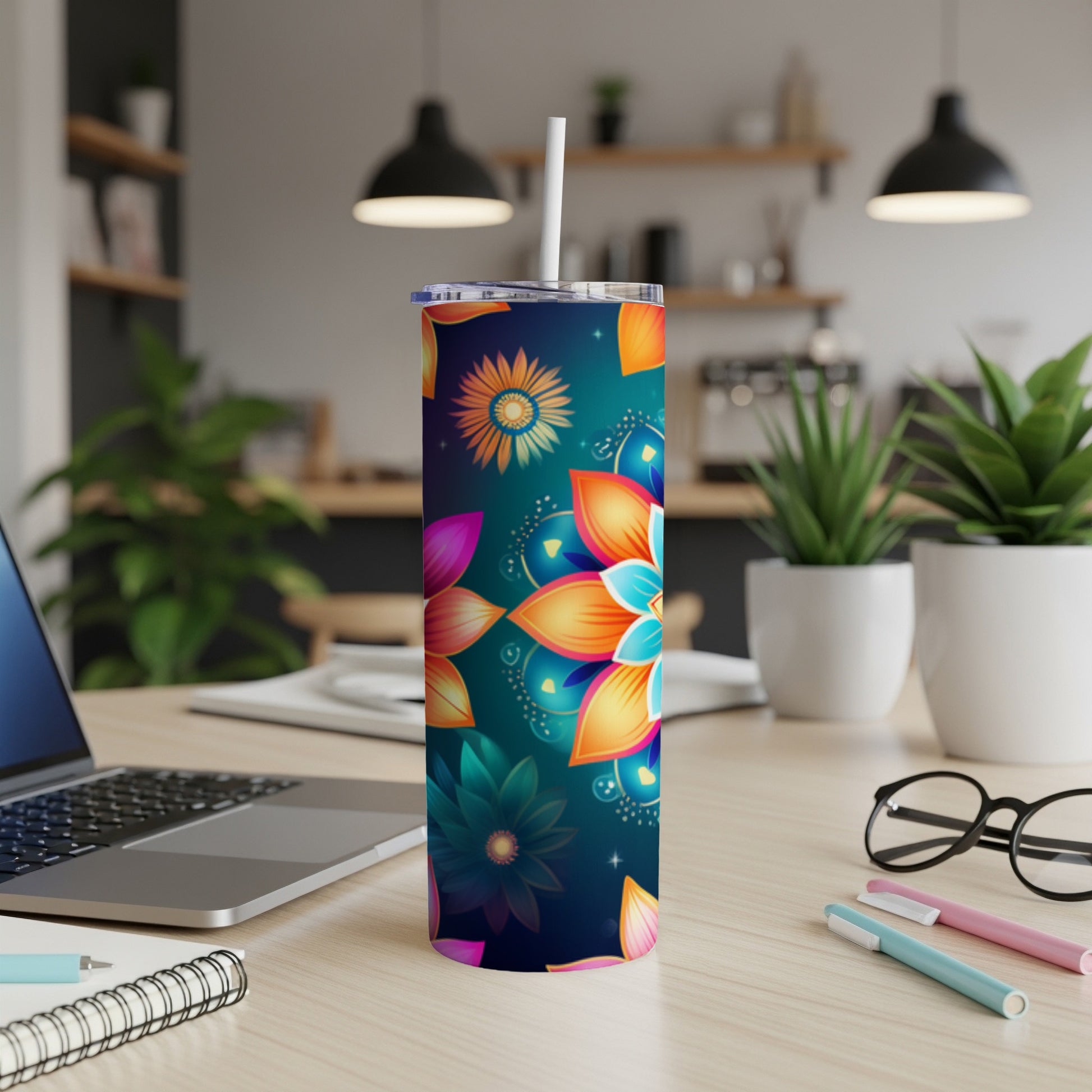 Floral patterned tumbler on a desk with laptop and pens.