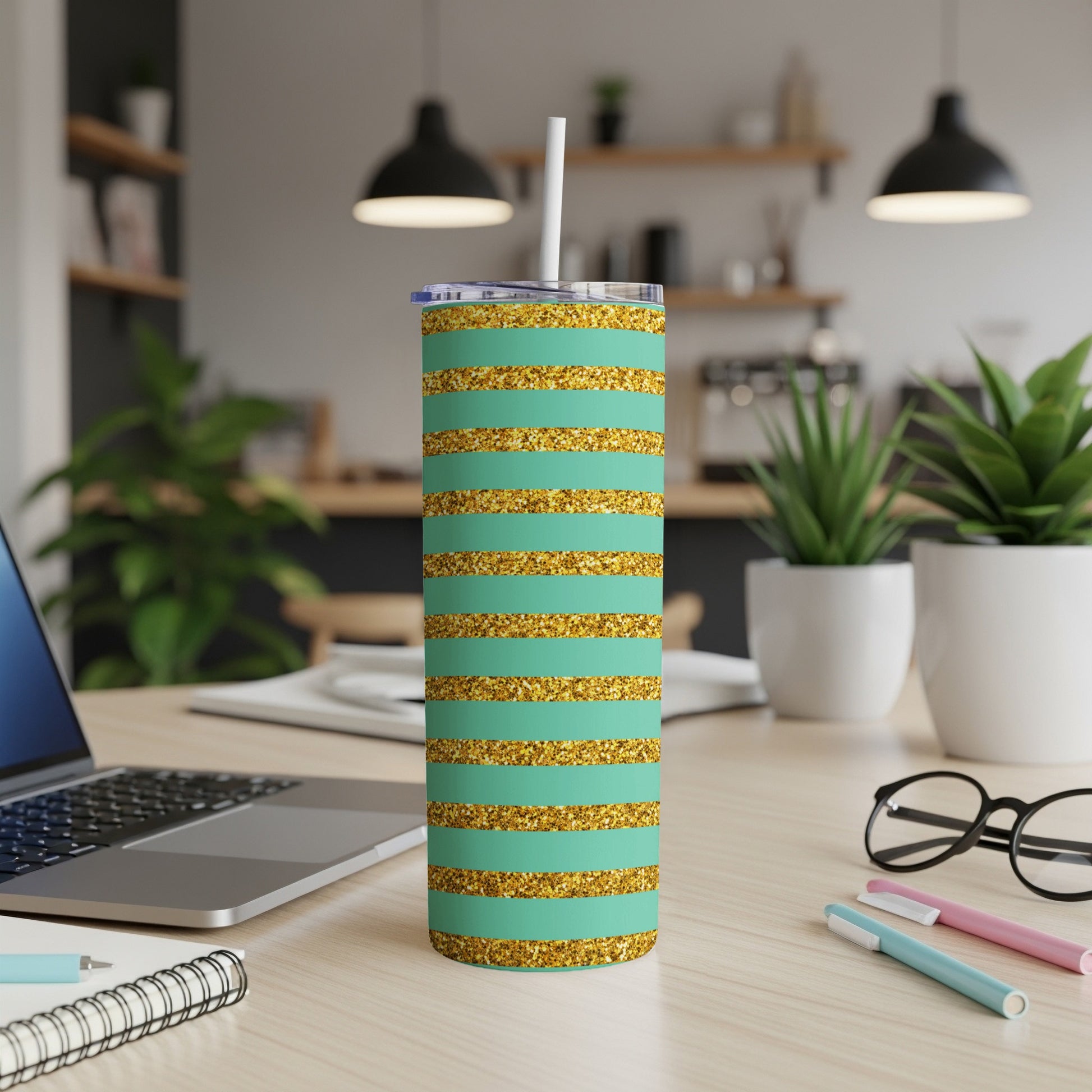 Teal tumbler with gold glitter stripes and a white straw.