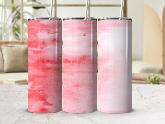 Three tumblers with pink watercolor patterns on a marble surface.