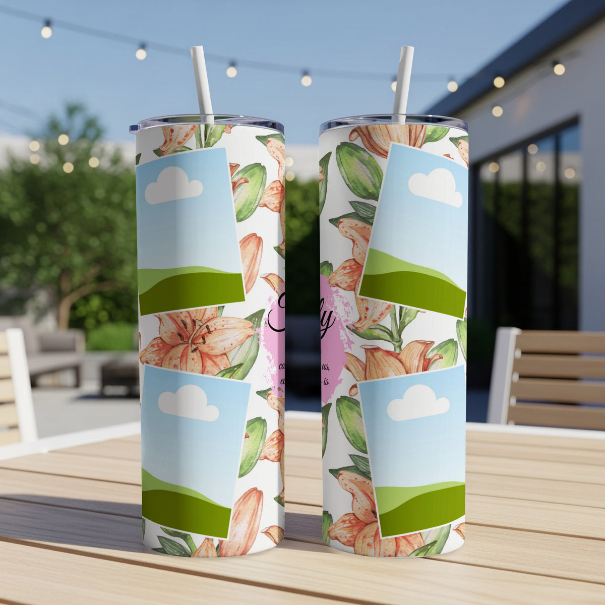 Two tumblers with floral pattern and framed landscape photos sit on a table.