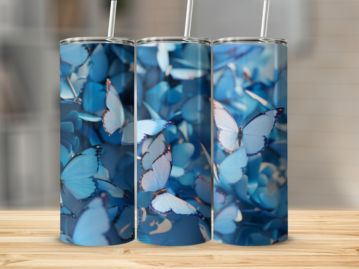 Three blue butterfly tumblers arranged in a row on a wooden surface.