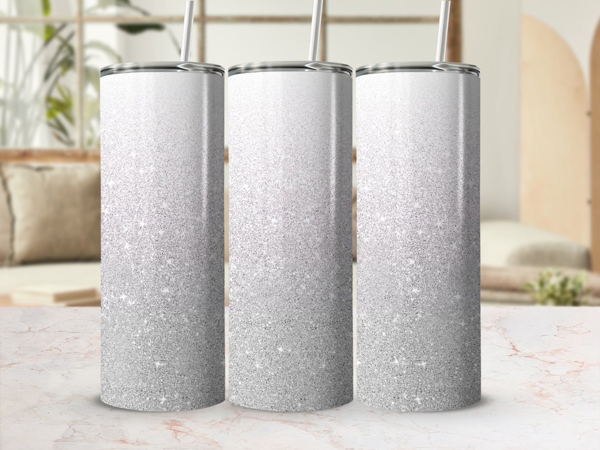 Three tall tumblers with silver glitter gradient and straw.