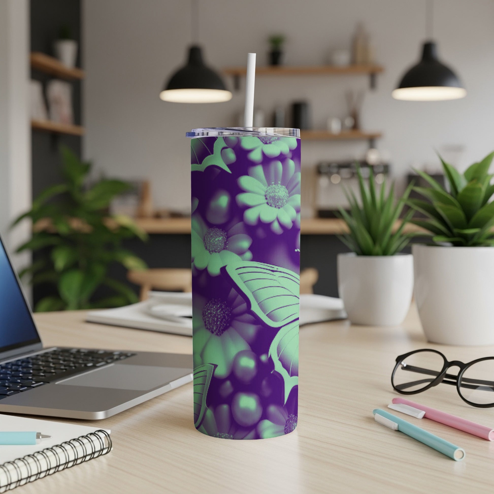 Purple and green floral tumbler with butterfly design on desk.
