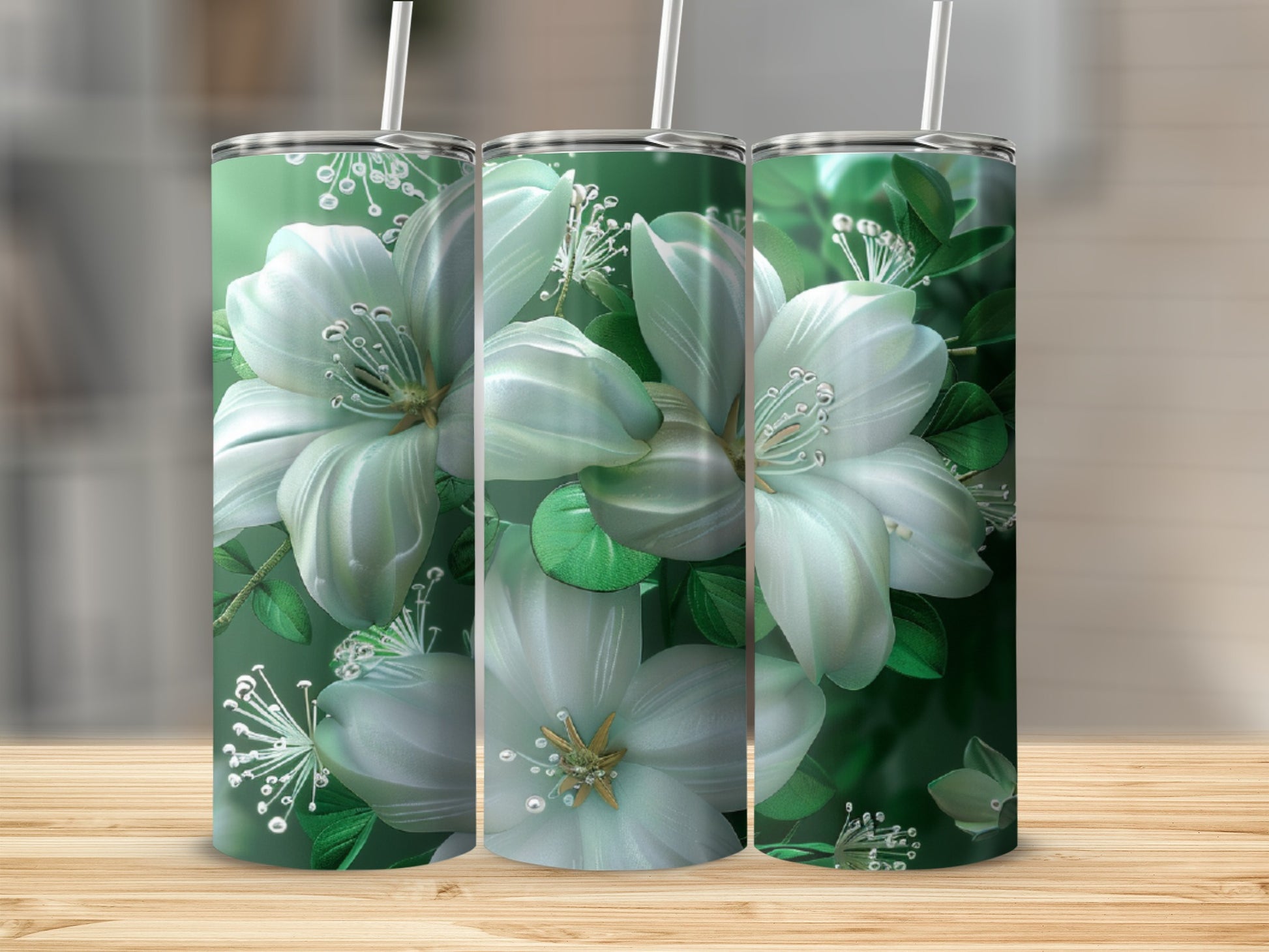 Three green tumblers with white floral designs on a wooden surface.