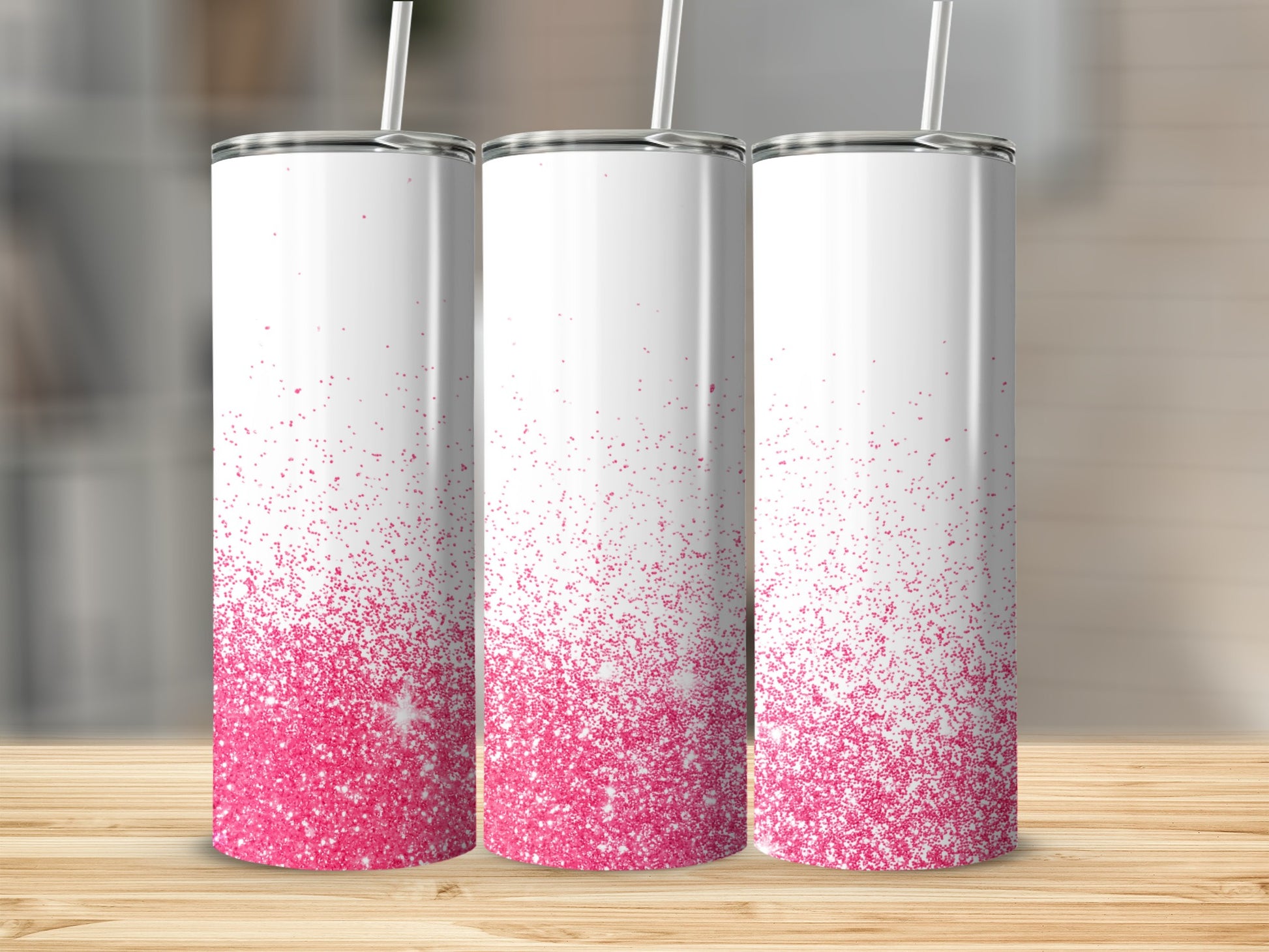 Three white tumblers with pink glitter gradient and straws.