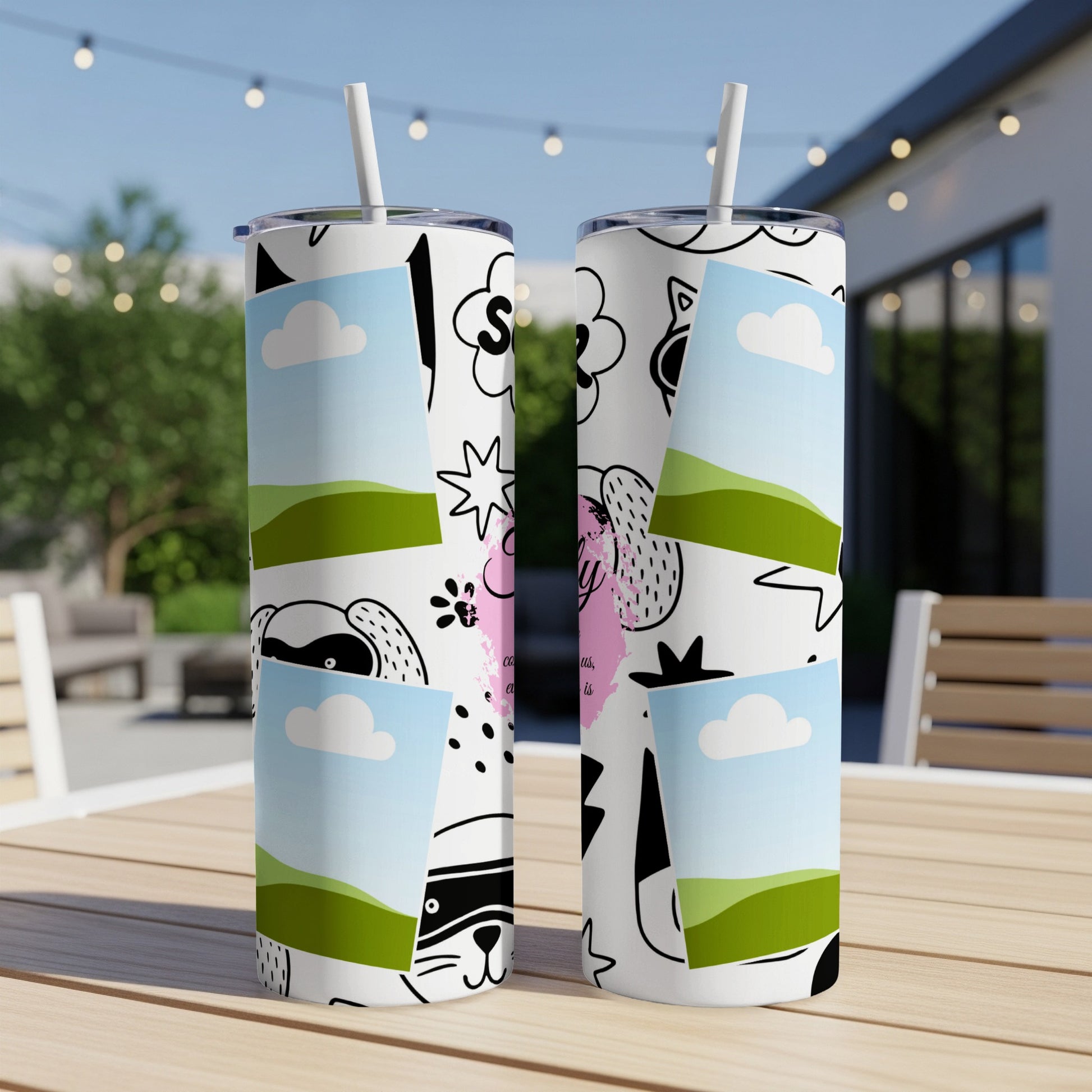 Two white tumblers with playful cartoon designs, clouds, and landscape scenes.