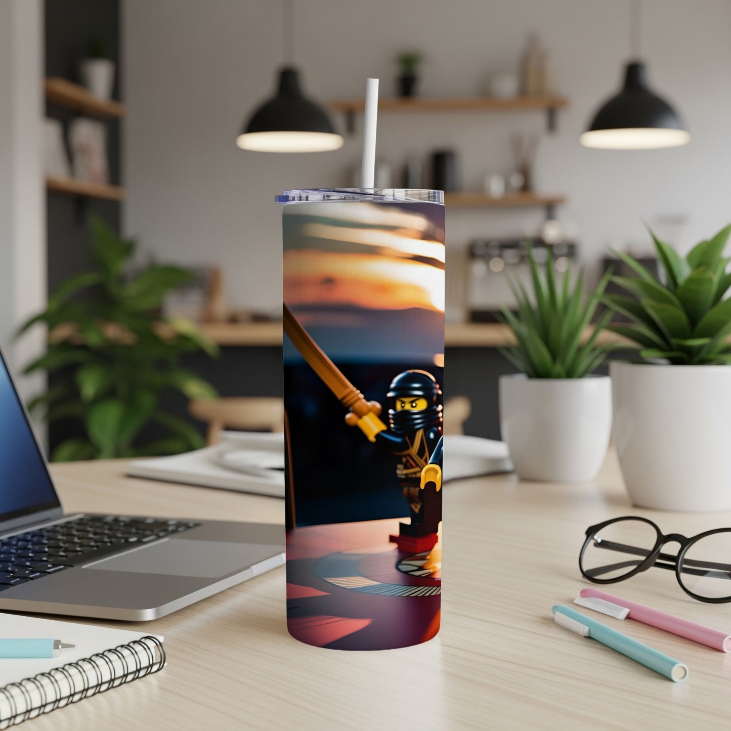 Ninja toy figure on a colorful tumbler with straw, desktop background.