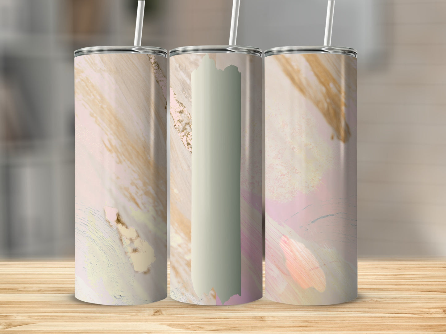 Three abstract pastel tumblers with brushstroke designs on a wooden surface.