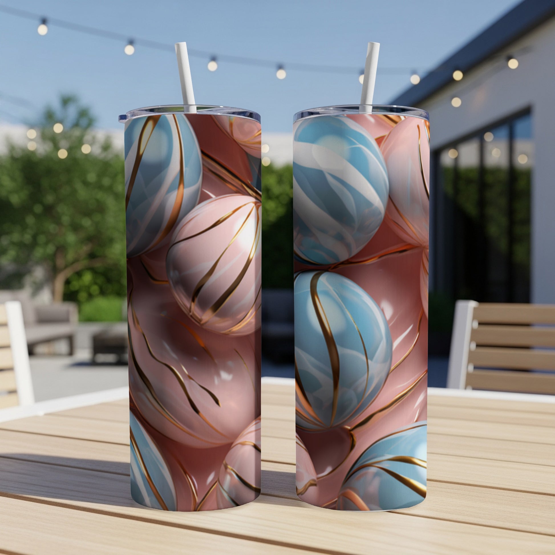 Two pink and blue marbled tumblers with gold accents on a wooden table.