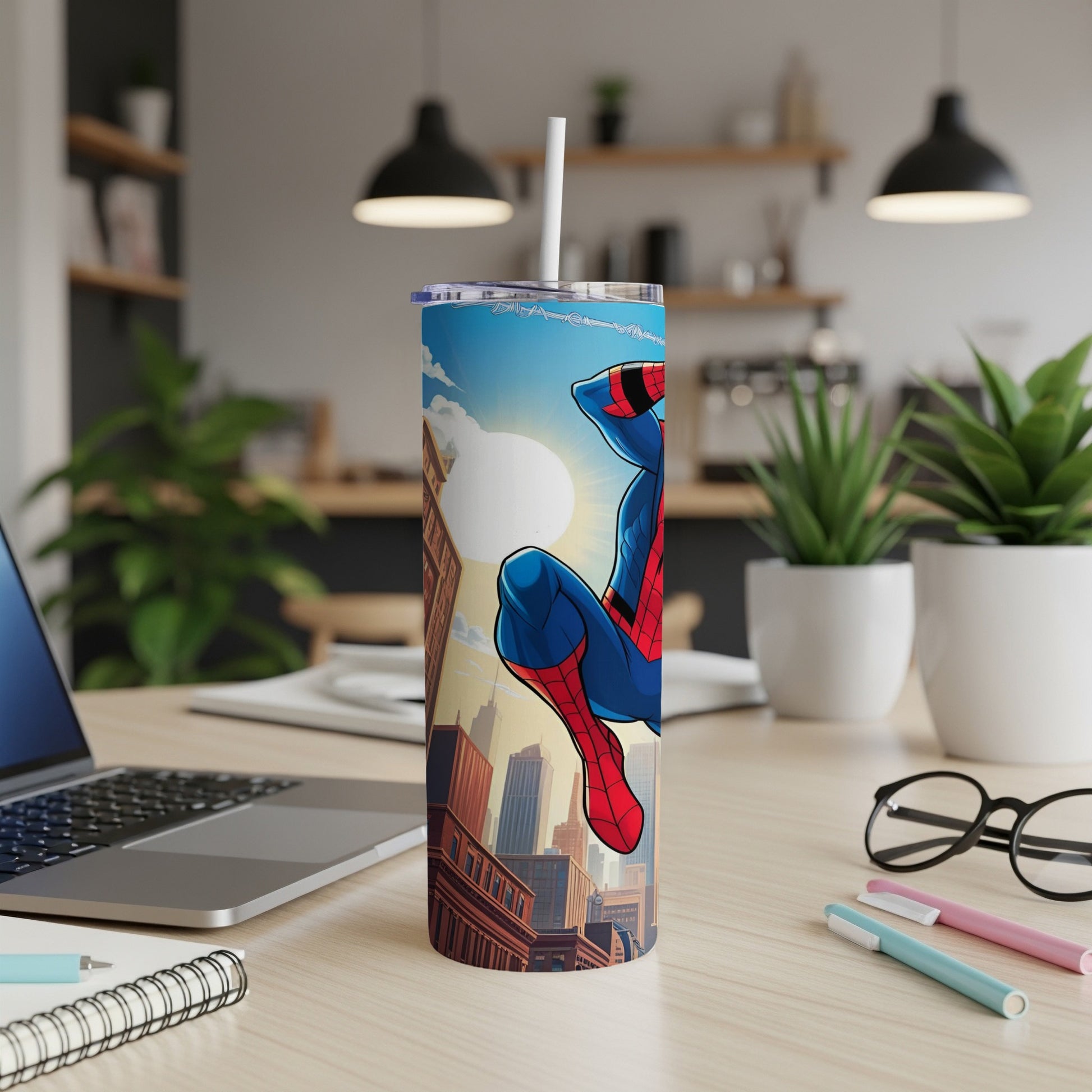 Spider-Man on a cityscape tumbler with straw, on a desk.