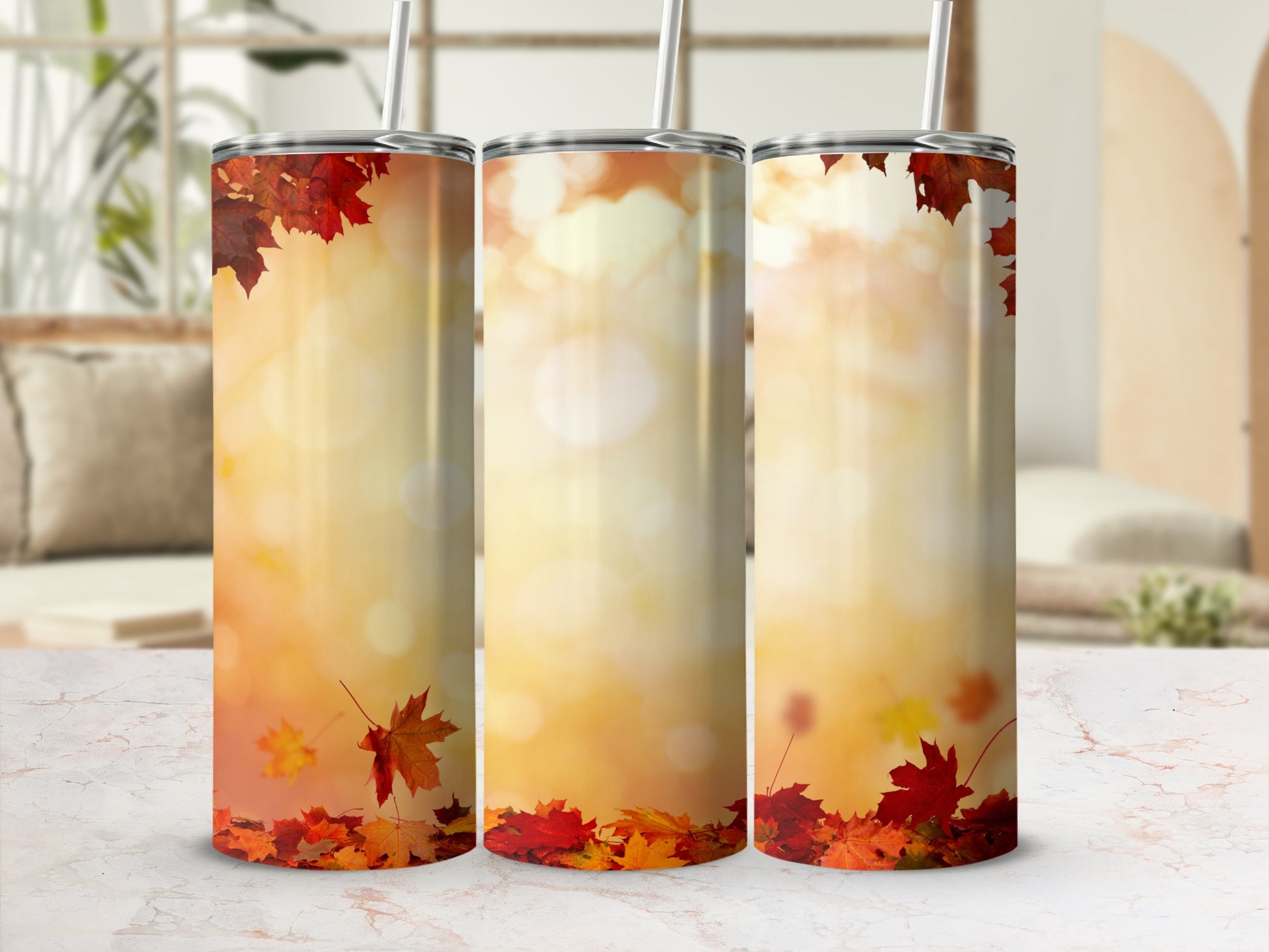 Three tumblers with fall leaves and bokeh background.