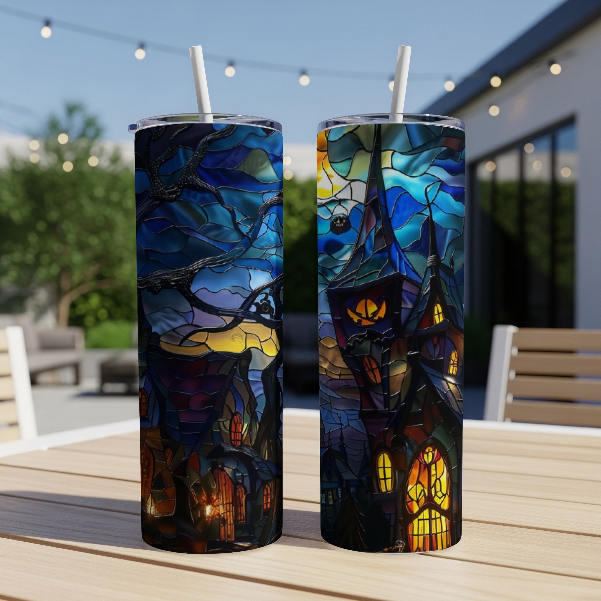 Two tumblers with stained-glass Halloween castle designs sit on a table.