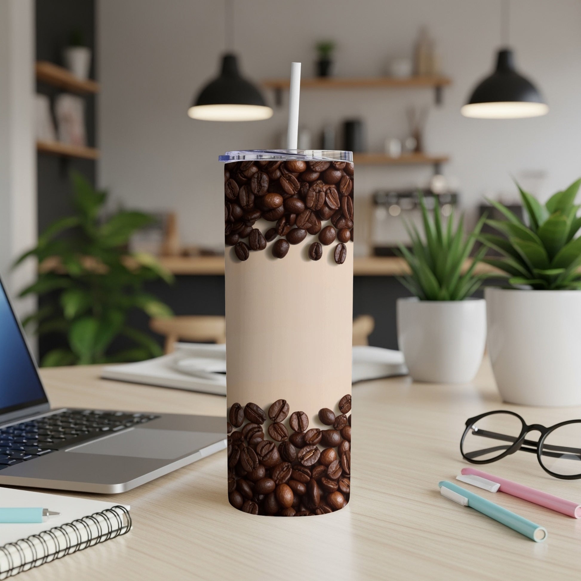 Tan tumbler with coffee beans, straw, and desk background.
