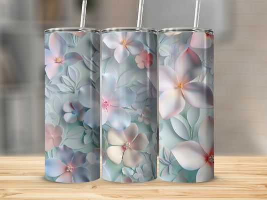 Three floral tumblers with pastel colors on a wooden surface.