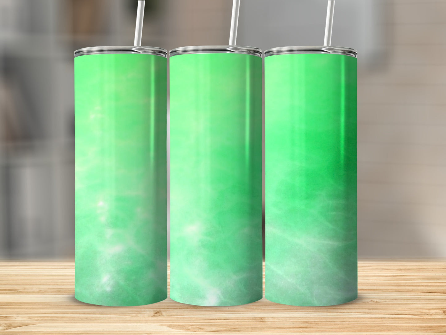 Three green gradient tumblers with white abstract patterns and straws.