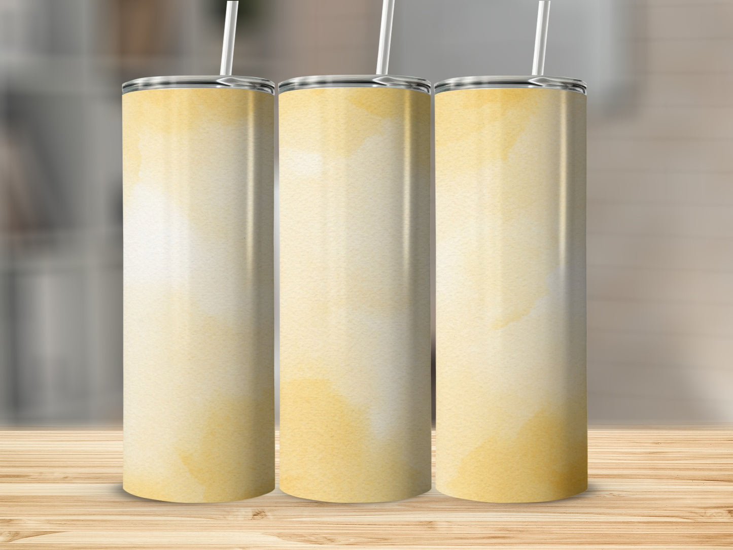 Three tall, tapered tumblers with a watercolor yellow abstract pattern.