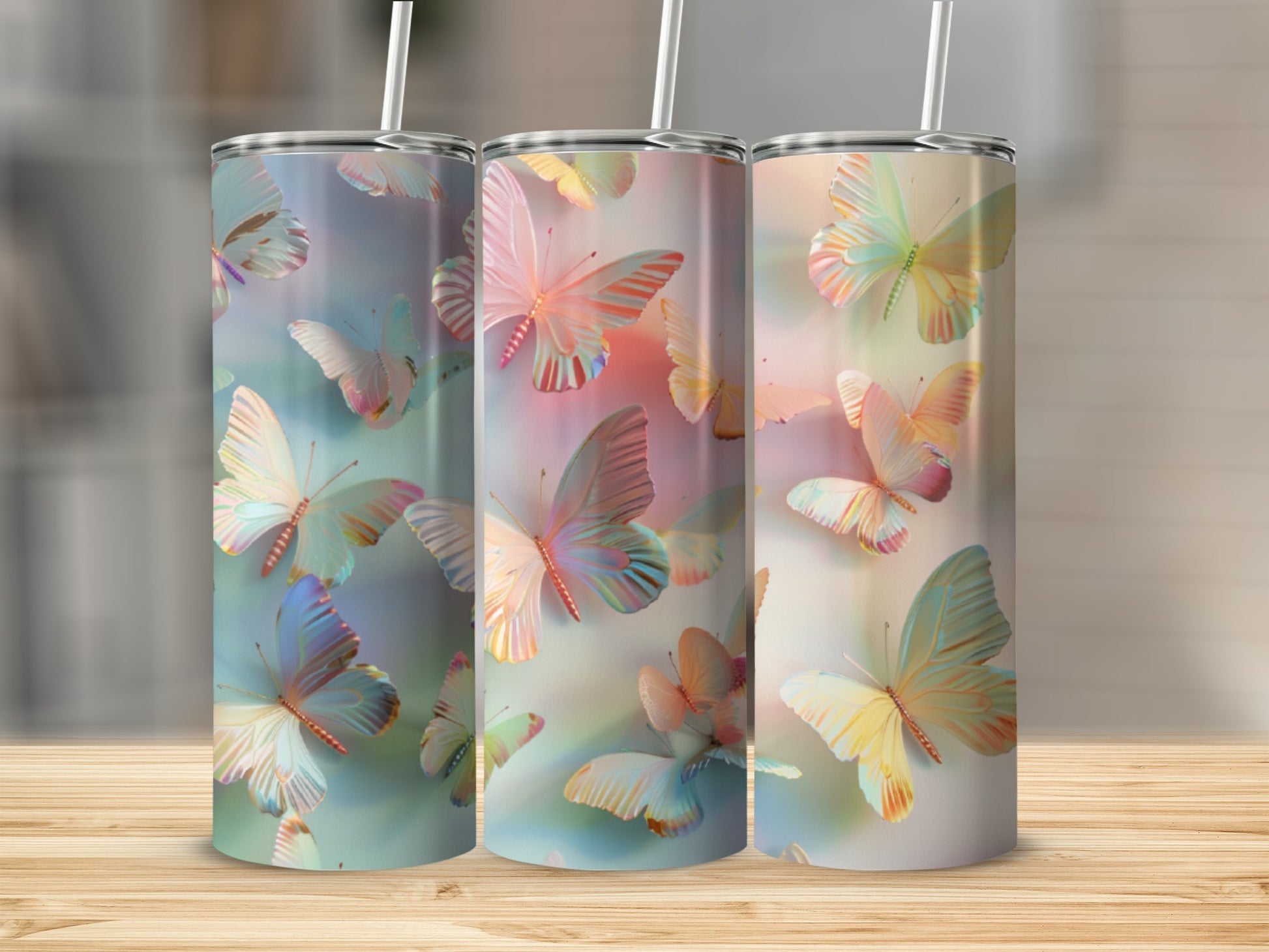 Three tumblers with pastel butterfly designs on a wooden surface.