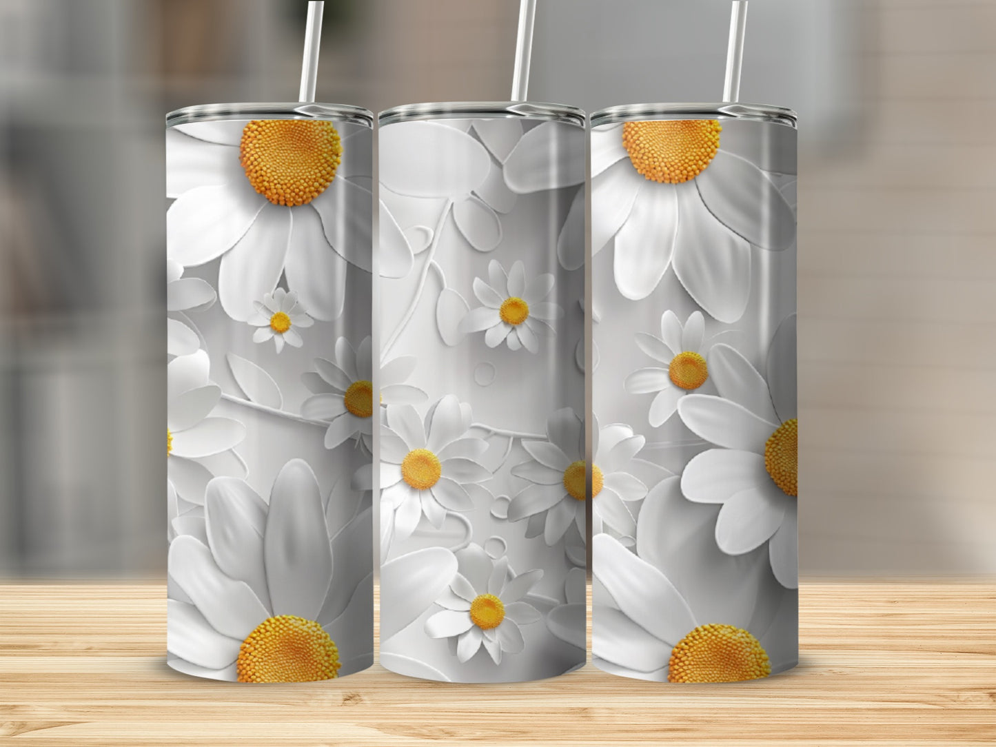 Three tumblers with white daisies and yellow centers on a wooden surface.