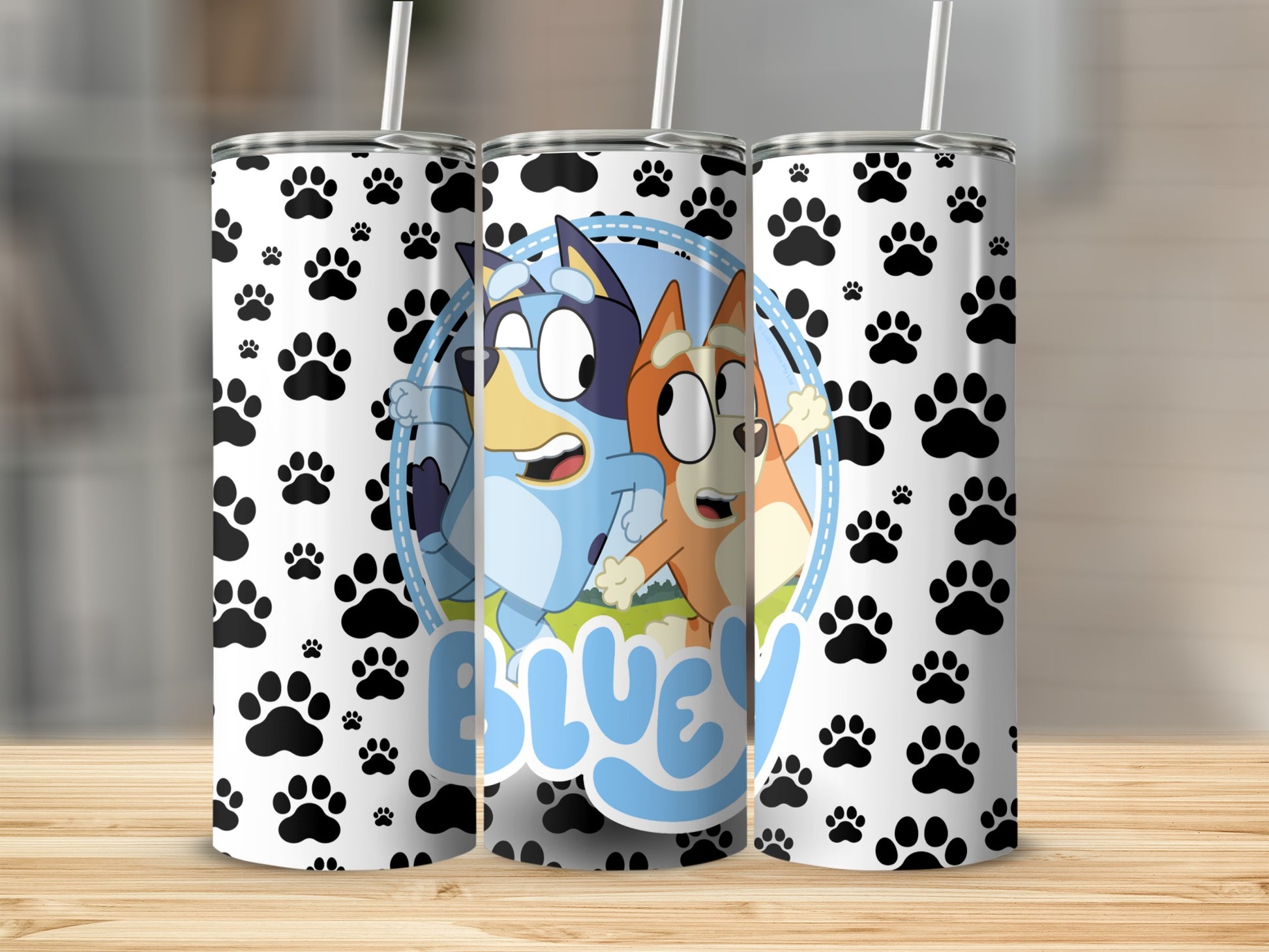 Bluey and Bingo characters on a tumbler with paw print pattern.