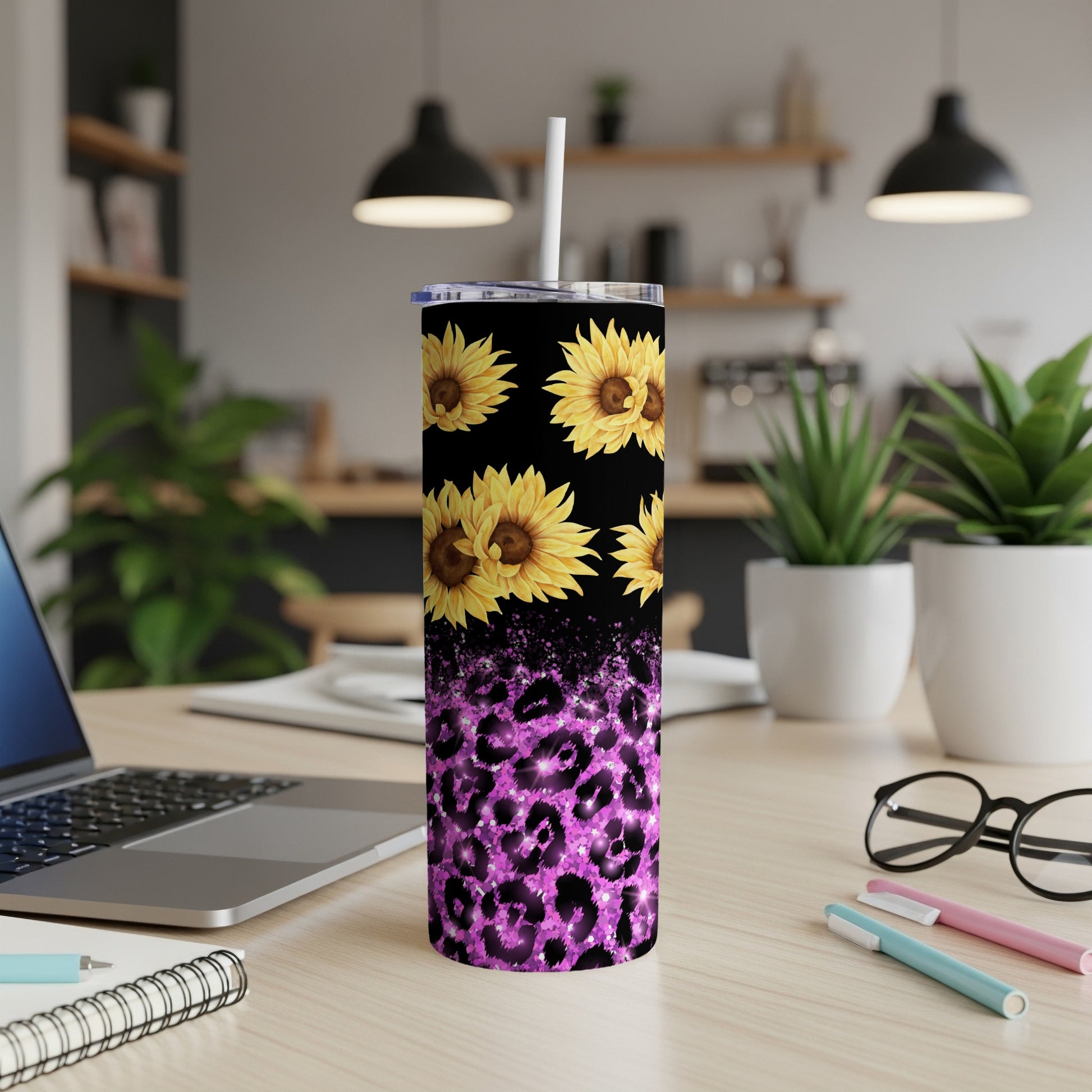 Sunflower and purple leopard print tumbler with straw on a desk.