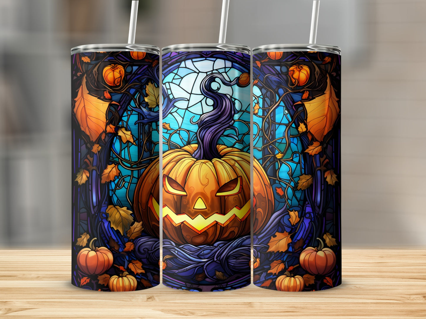 Stained glass pumpkin on a tumbler, surrounded by autumn leaves and branches.