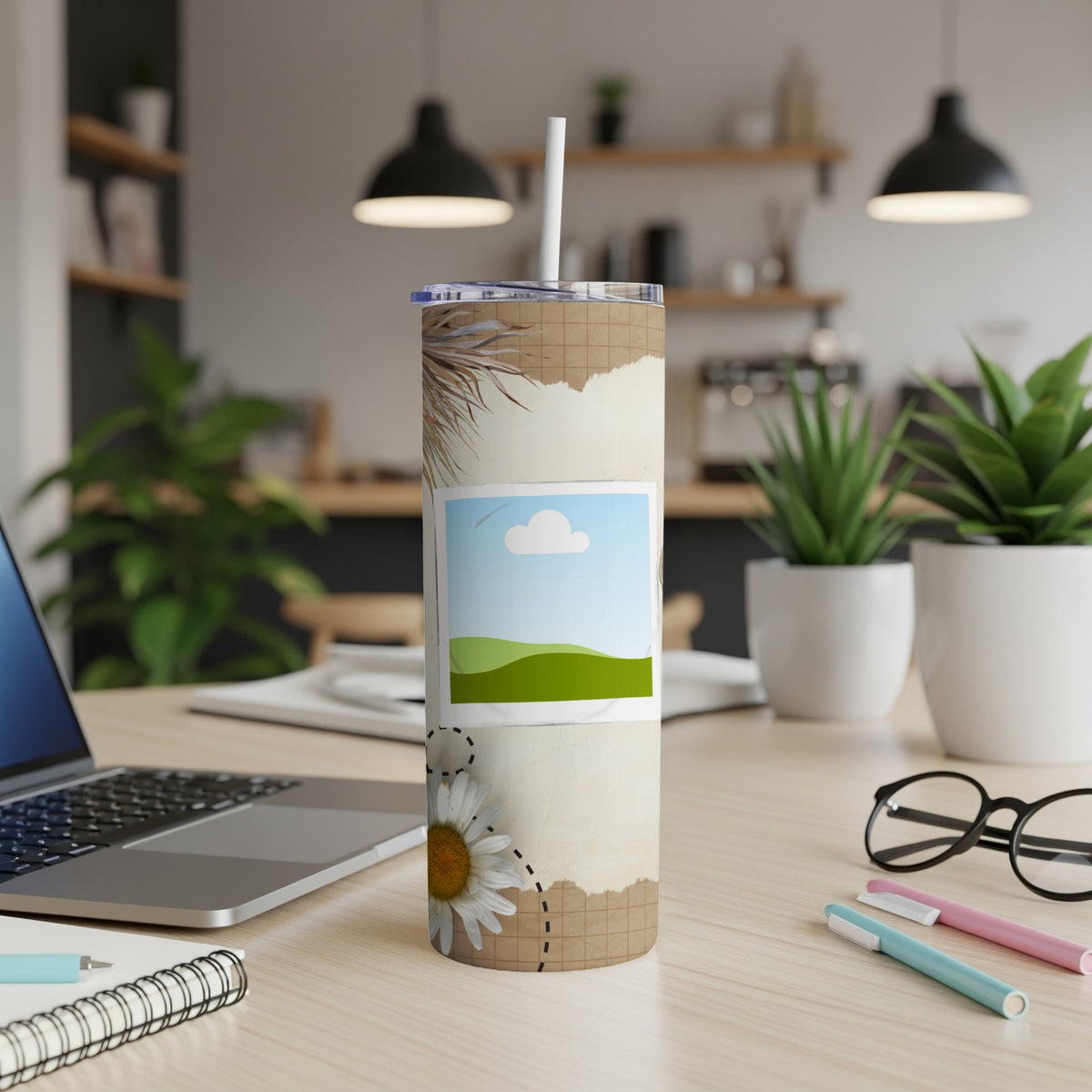 Tumbler with daisy and torn paper design, shown on a desk.