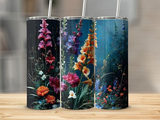 Three tumblers featuring vibrant floral art on a wooden surface.