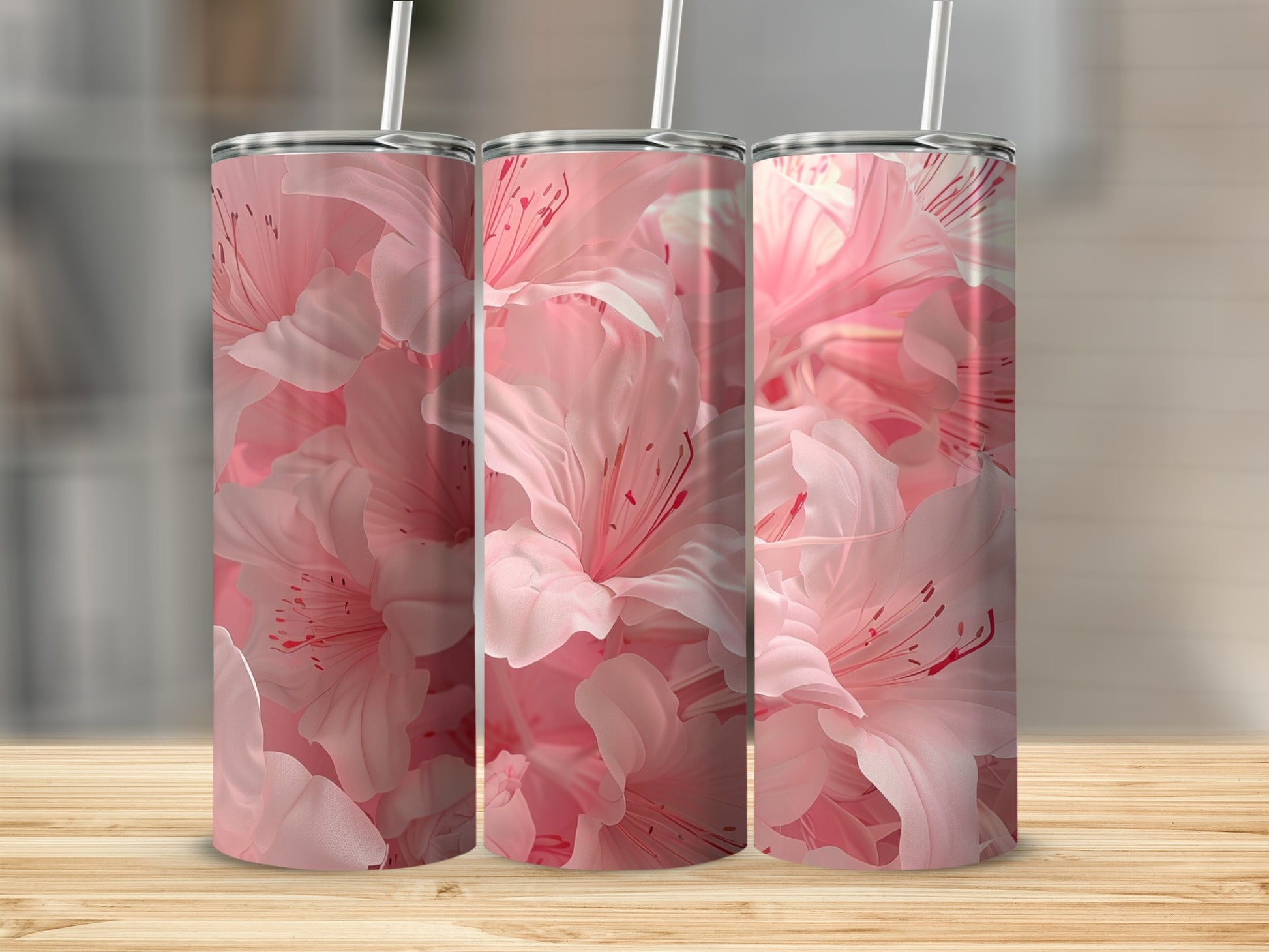 Three tumblers with pink floral patterns on a wooden surface.