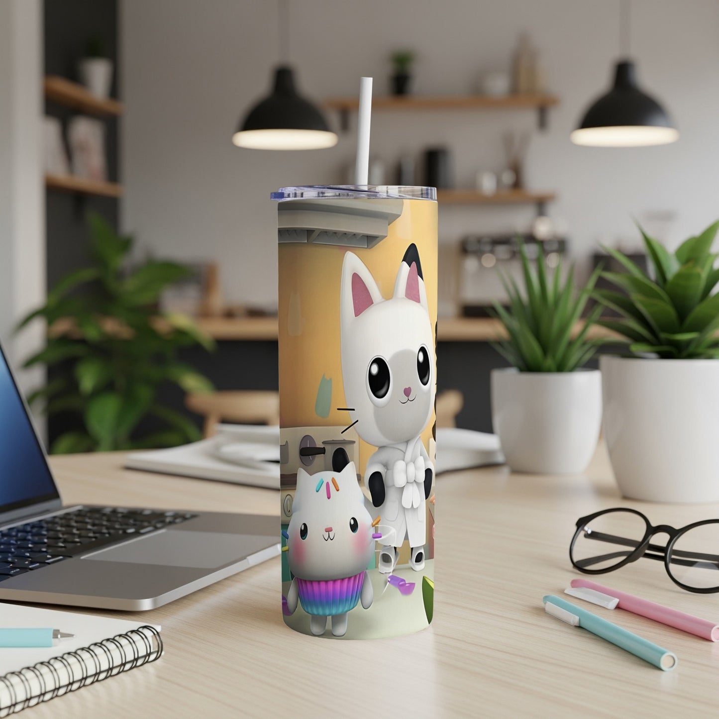 Tumbler with cartoon cats and pastel accents on a desk.