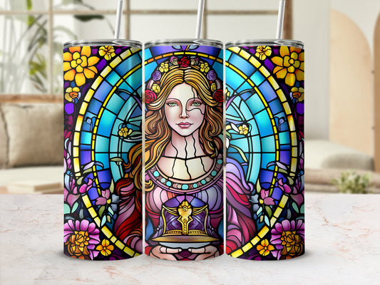 Stained glass tumbler with a woman holding a book, surrounded by flowers.