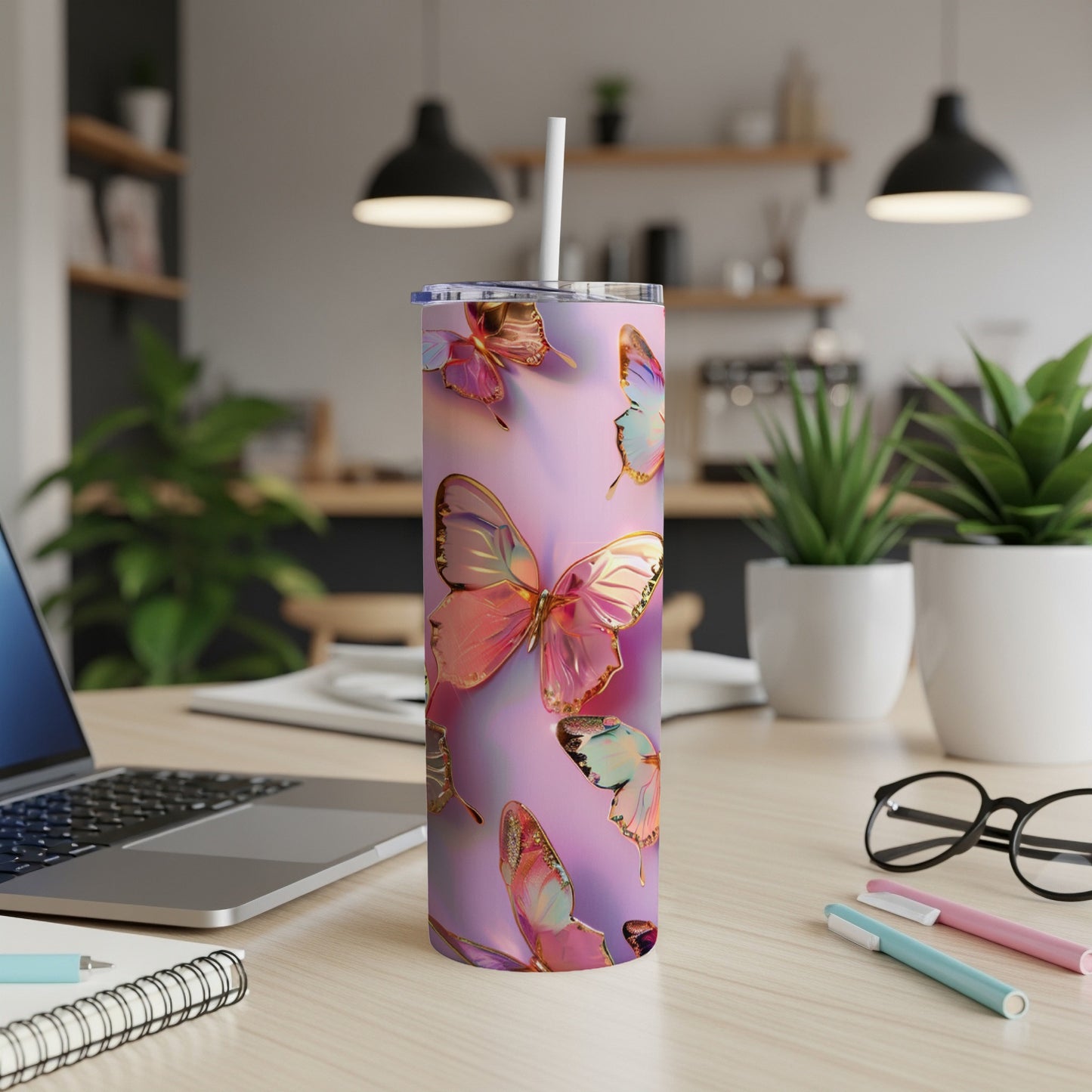 Purple and pink tumbler with butterfly design, straw, and office desk background.