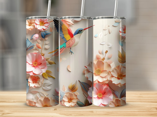 Three tumblers with floral and hummingbird designs on a wooden surface.