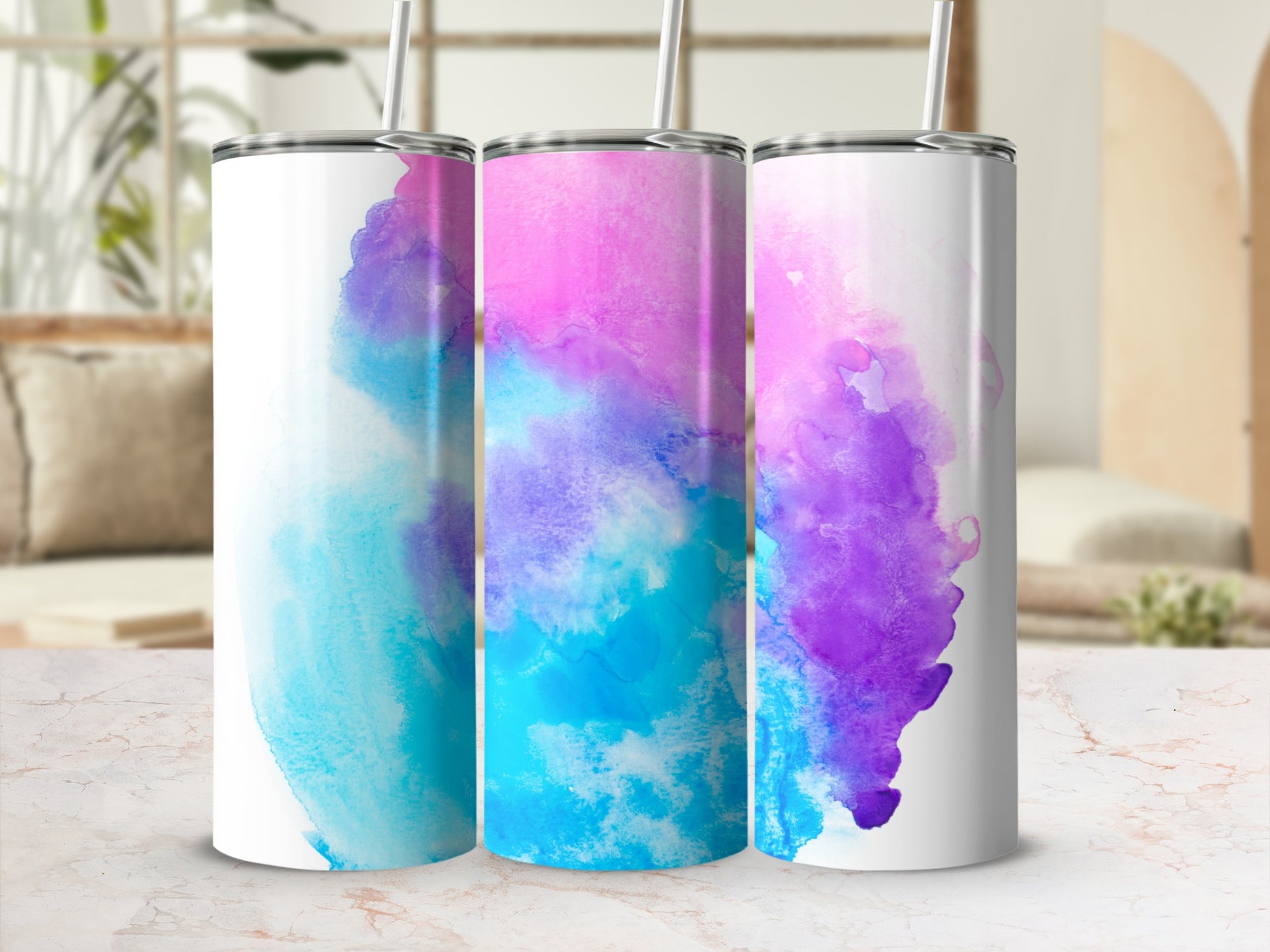 Three tumblers with watercolor designs in blue, pink, and purple hues.