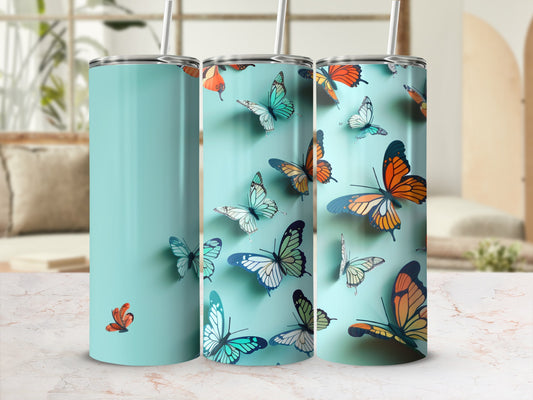 Three teal tumblers with colorful butterflies in flight.