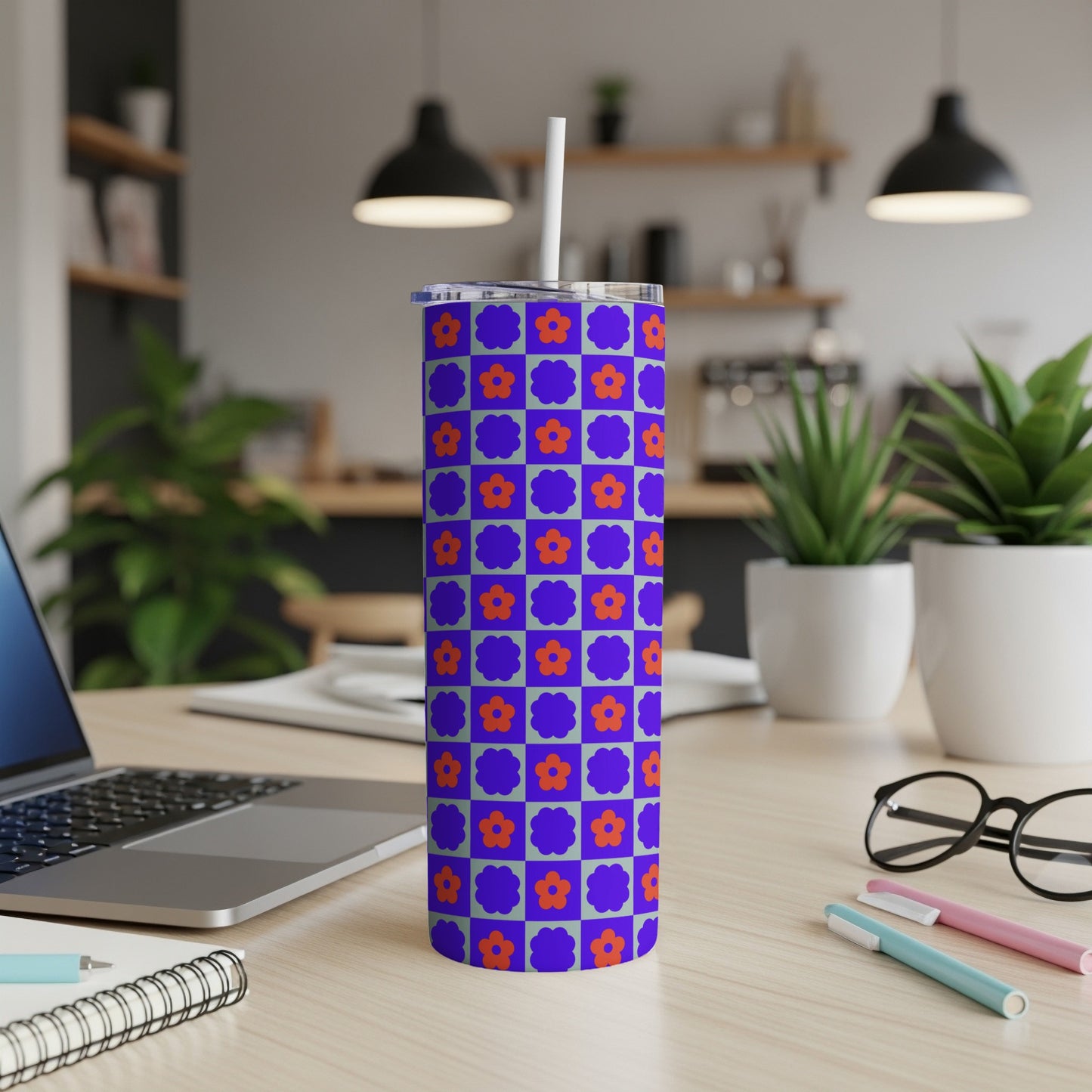 Blue tumbler with a purple and orange checkerboard floral pattern.