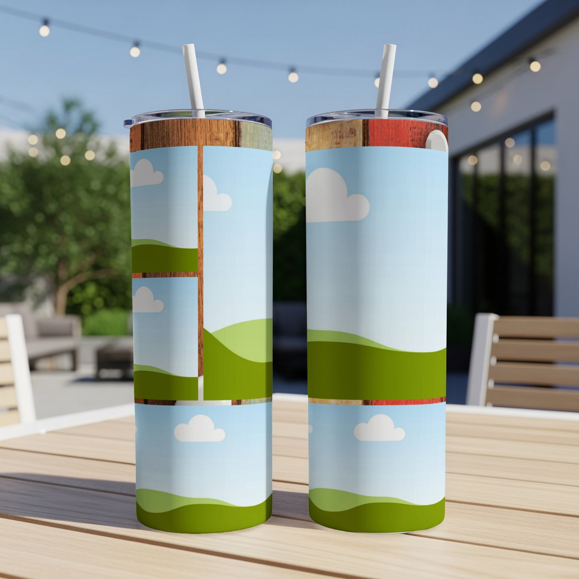 Two skinny tumblers with a cartoon landscape design sit on a wooden table.