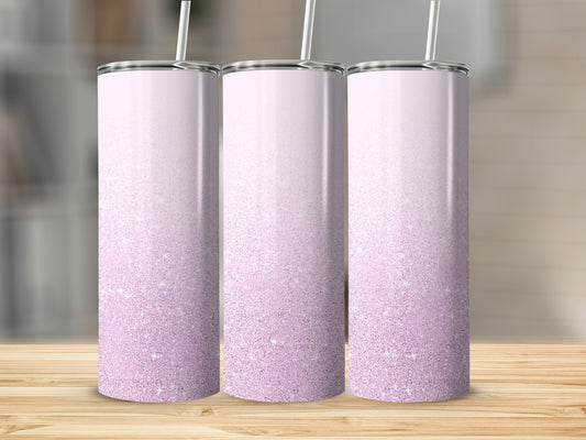 Three tall, skinny tumblers with a pink glitter ombre design and straw.