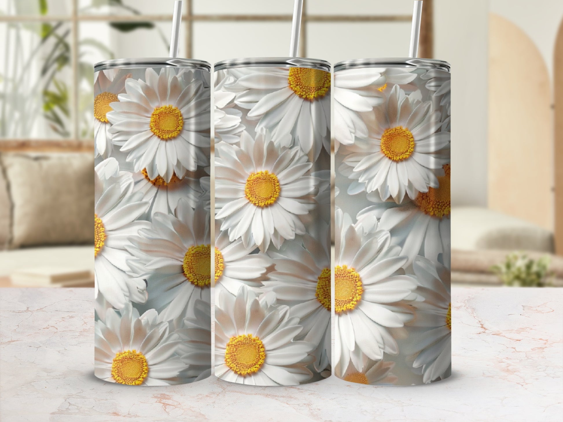 Three daisy print tumblers with straws stand on a patterned surface.