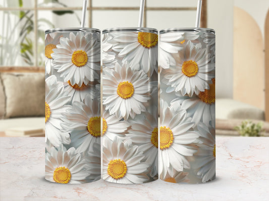 Three daisy print tumblers with straws stand on a patterned surface.