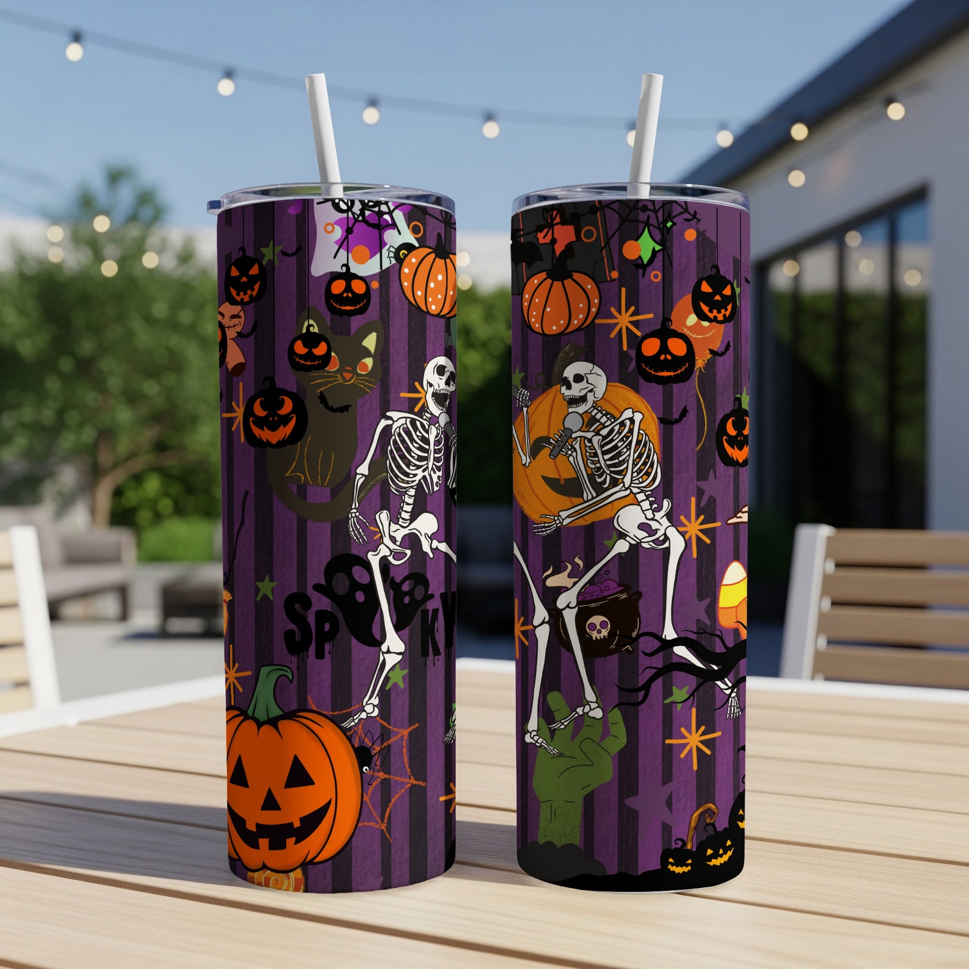 Two tumblers with Halloween-themed designs featuring skeletons, pumpkins, and a black cat on a purple striped background.