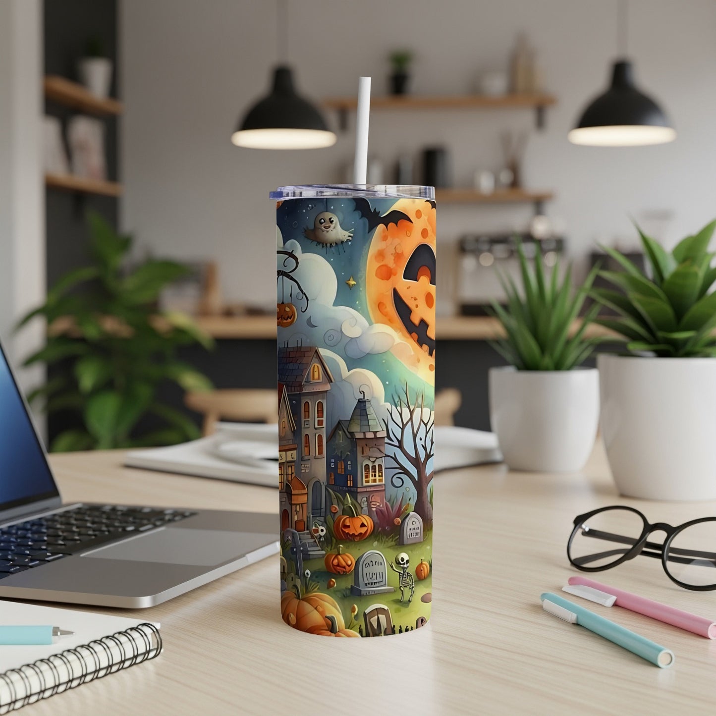 Tall tumbler with a Halloween scene featuring haunted houses, pumpkins, a skeleton, and a Jack-o'-lantern moon.