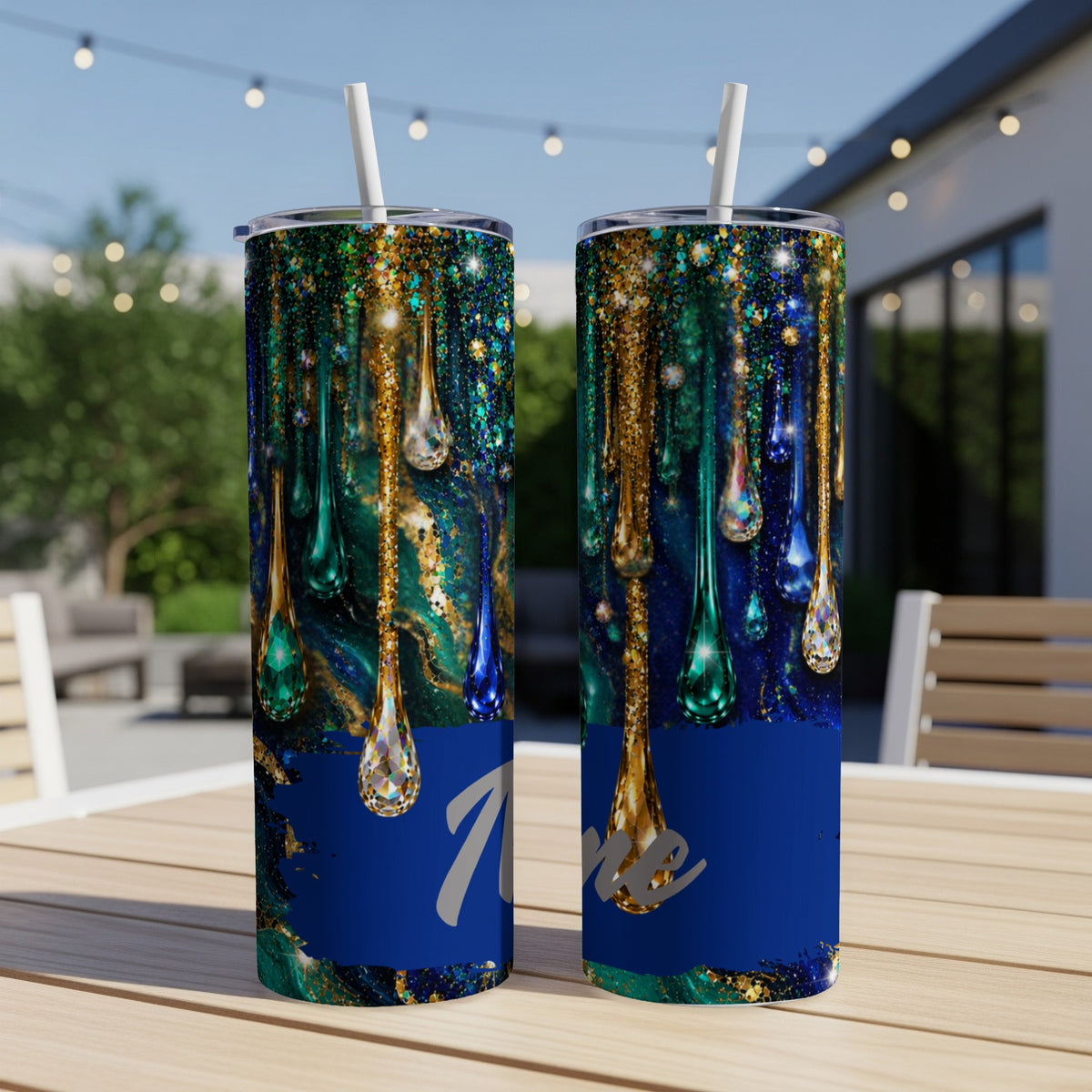 Two tumblers with a dripping jewel and glitter design on a table.