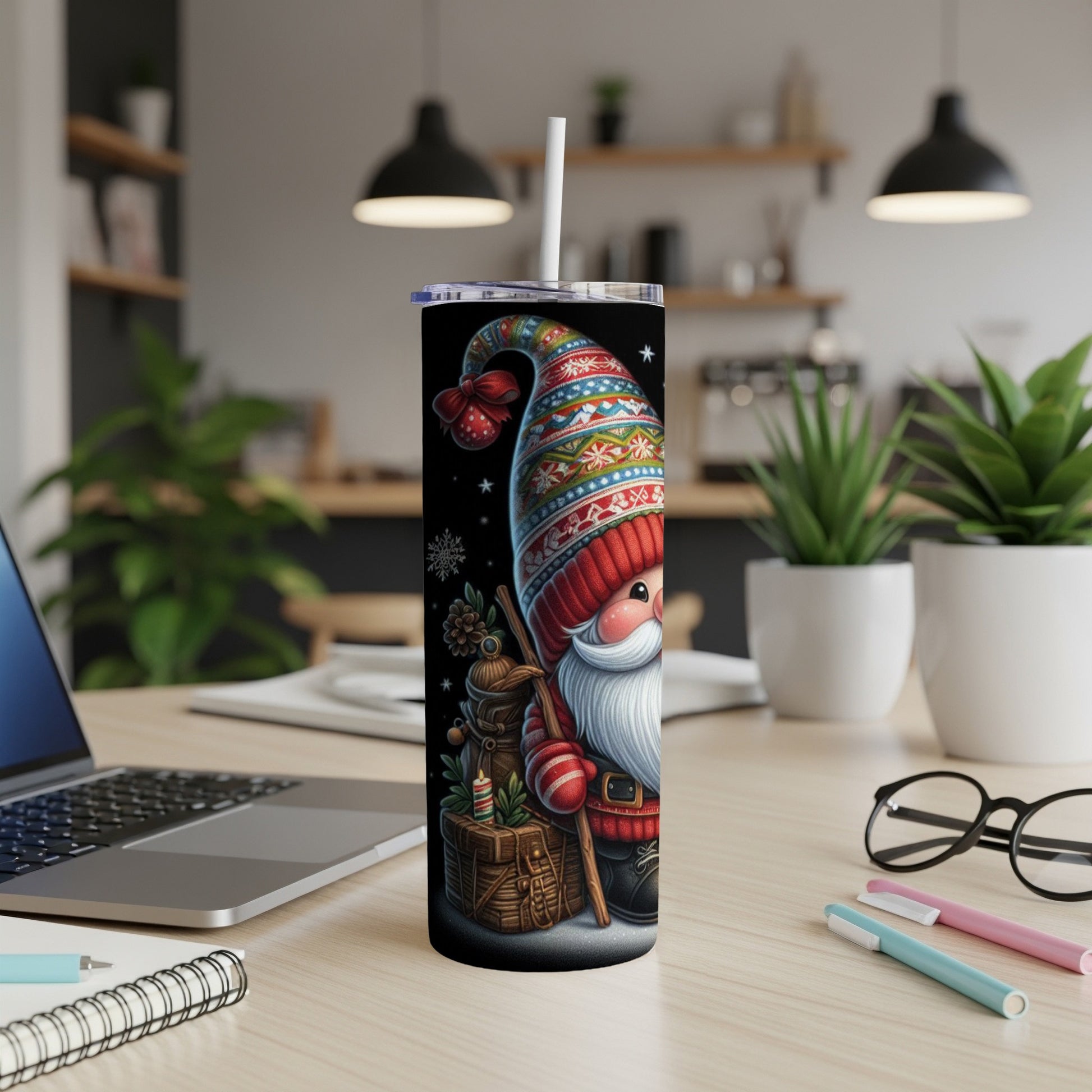 Santa Claus gnome tumbler with snowflakes and striped hat on desk.