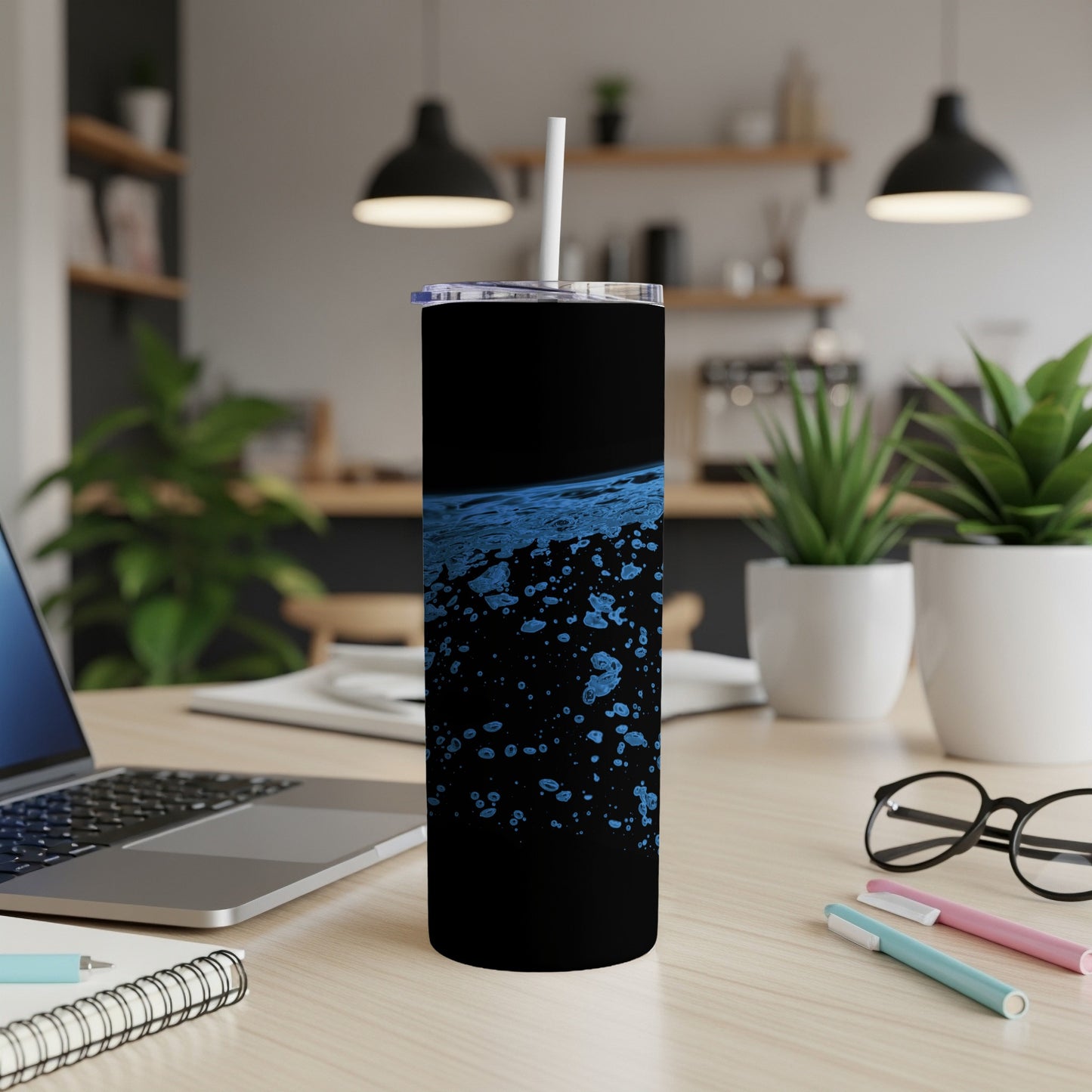 Black tumbler with blue abstract splatter pattern and white straw.